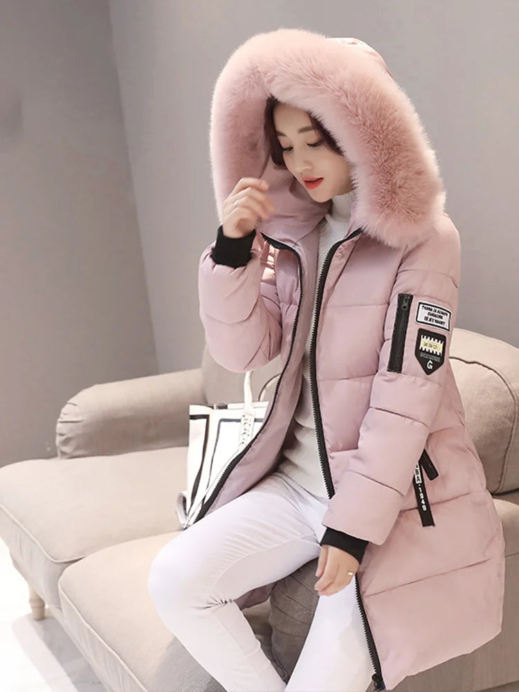 Women winter parka with fur collar hood and patch design sitting on sofa.