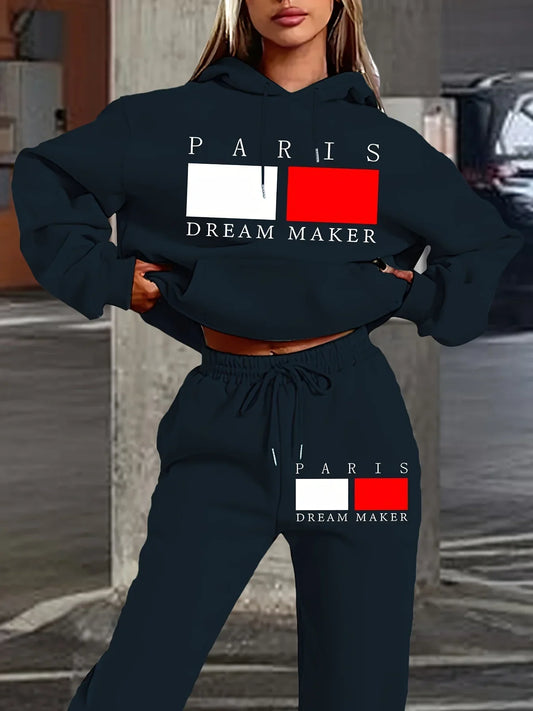 Woman tracksuit two-piece set with hooded sweatshirt and sweatpants featuring "Paris Dream Maker" print in black, casual sports outfit.